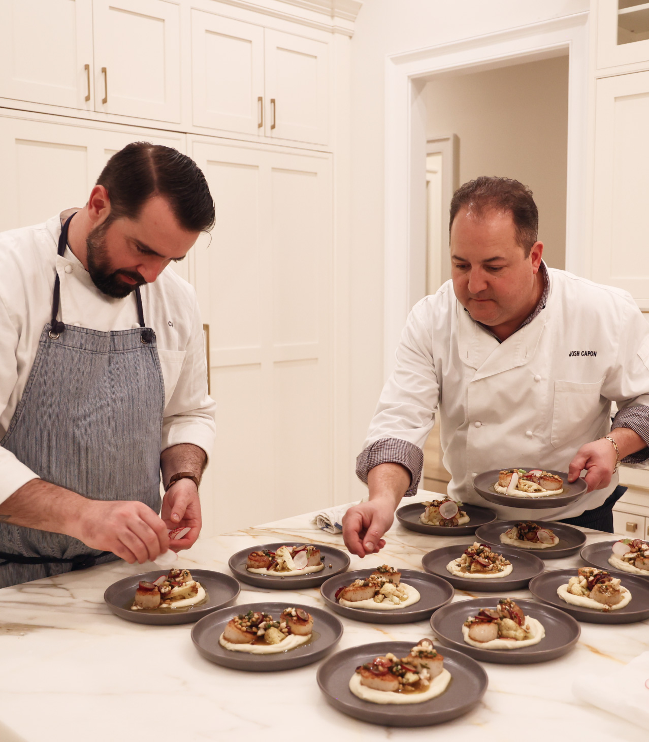 Chef Capon Plating Food with another Chef